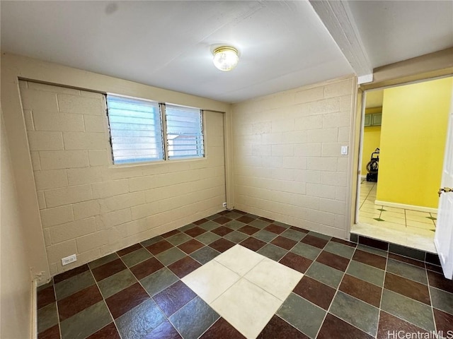 spare room featuring concrete block wall