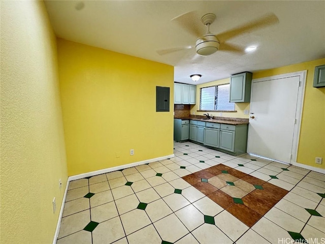 kitchen featuring electric panel, baseboards, gray cabinetry, and a ceiling fan