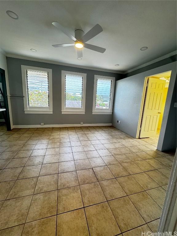 tiled empty room featuring ceiling fan, baseboards, and ornamental molding