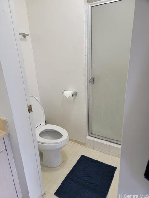 bathroom featuring tile patterned floors, baseboards, a shower stall, and toilet