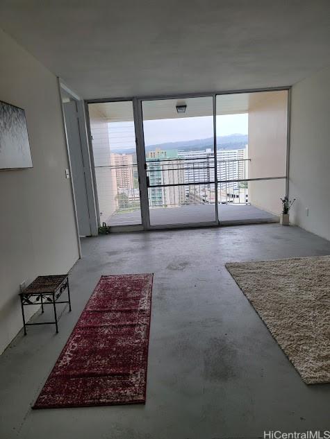 unfurnished living room featuring concrete floors, expansive windows, and plenty of natural light