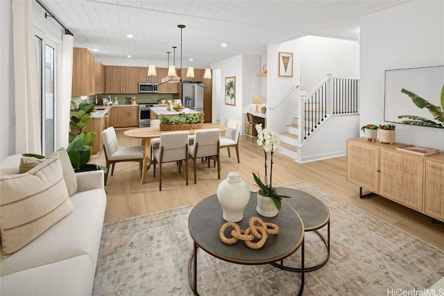 living area featuring recessed lighting, stairway, and light wood-style flooring