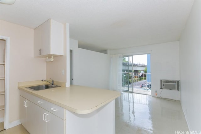 2873 S King St Unit 203, Honolulu, HI 96826 - kitchen with a wall mounted AC, light countertops, baseboards, and a sink