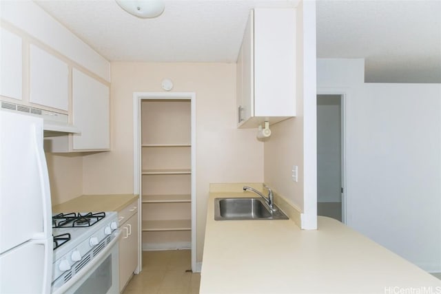 2873 S King St Unit 203, Honolulu, HI 96826 - kitchen featuring white appliances, a sink, light countertops, under cabinet range hood, and white cabinetry