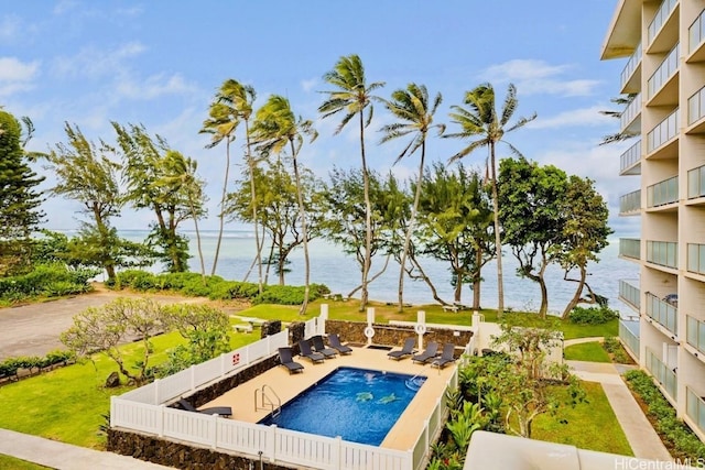 pool featuring a patio area, a fenced backyard, and a water view