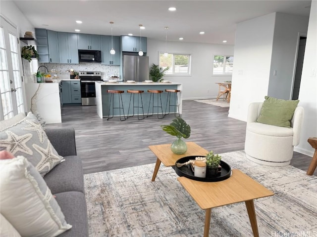 living area with dark wood finished floors, baseboards, and recessed lighting