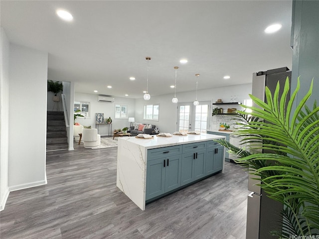 kitchen featuring an AC wall unit, open floor plan, recessed lighting, wood finished floors, and open shelves