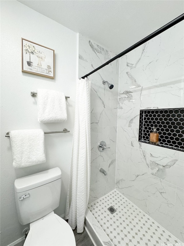 bathroom with a shower stall and toilet