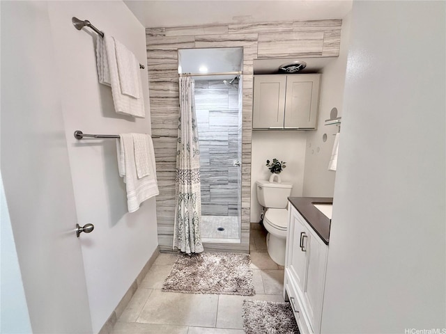 bathroom featuring toilet, tile patterned floors, baseboards, a shower stall, and vanity