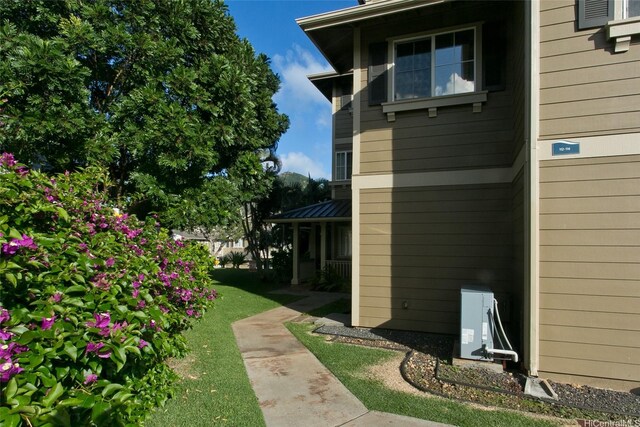 view of side of property with a yard and ac unit