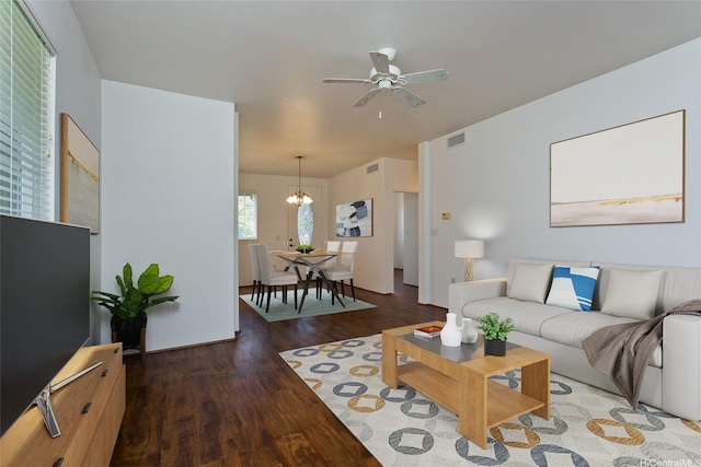 living area featuring wood finished floors, visible vents, and ceiling fan with notable chandelier