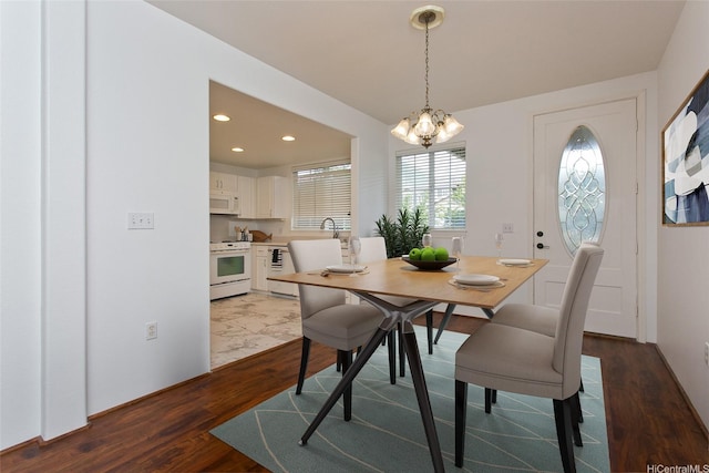 dining room with an inviting chandelier, recessed lighting, and dark wood finished floors
