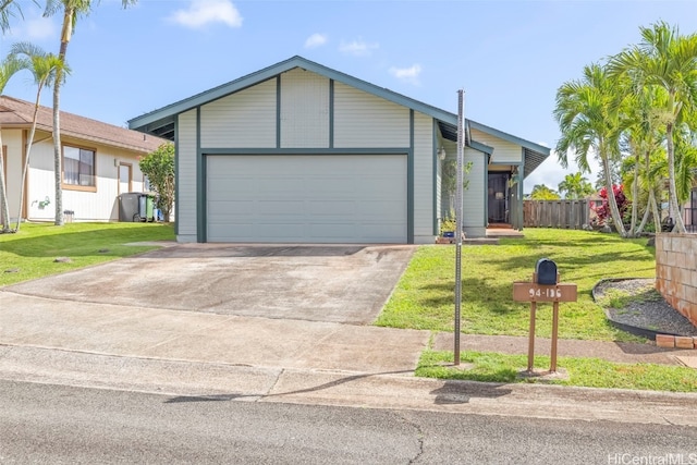 view of front of property with concrete driveway, a garage, fence, and a front lawn