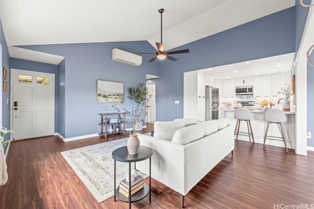 living room featuring a wall unit AC, vaulted ceiling, baseboards, dark wood finished floors, and a ceiling fan