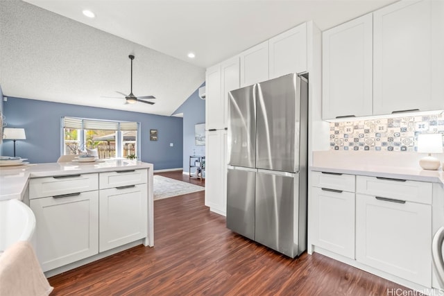 kitchen with white cabinetry, lofted ceiling, dark wood-style flooring, freestanding refrigerator, and a ceiling fan