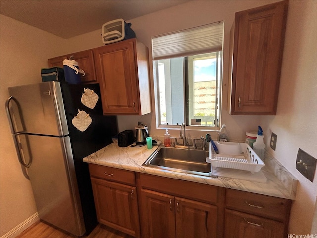 94-203 Paioa Pl Unit P201, Waipahu, HI 96797 - kitchen featuring freestanding refrigerator, brown cabinets, light countertops, and wood finished floors