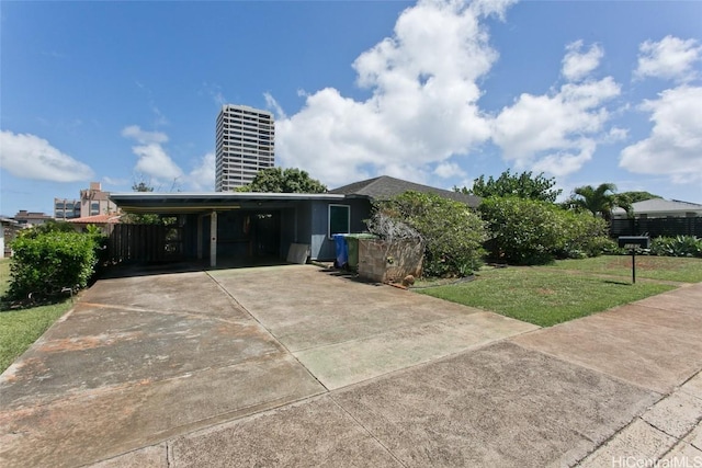 exterior space with an attached carport, a front yard, and driveway