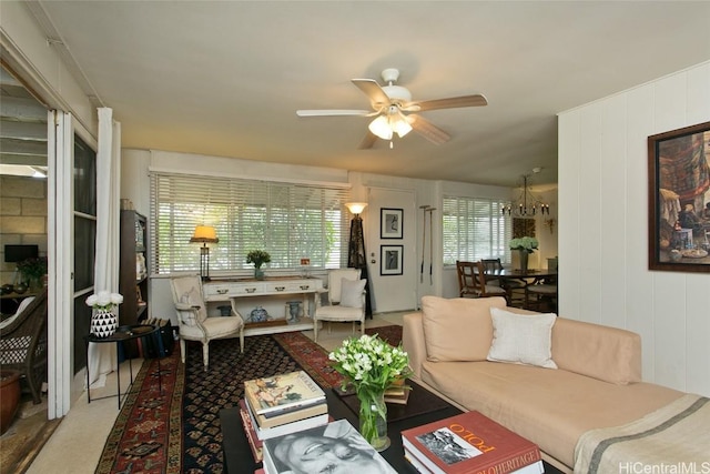 living room with ceiling fan with notable chandelier