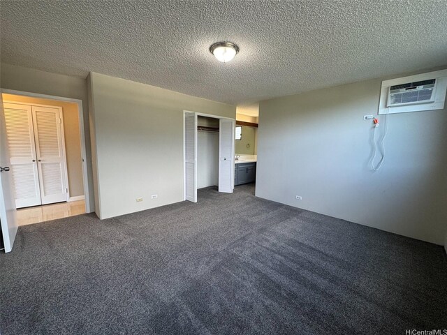 1808 Punahou St Unit 602, Honolulu, HI 96822 - unfurnished bedroom featuring a wall unit AC, dark colored carpet, a textured ceiling, and a closet