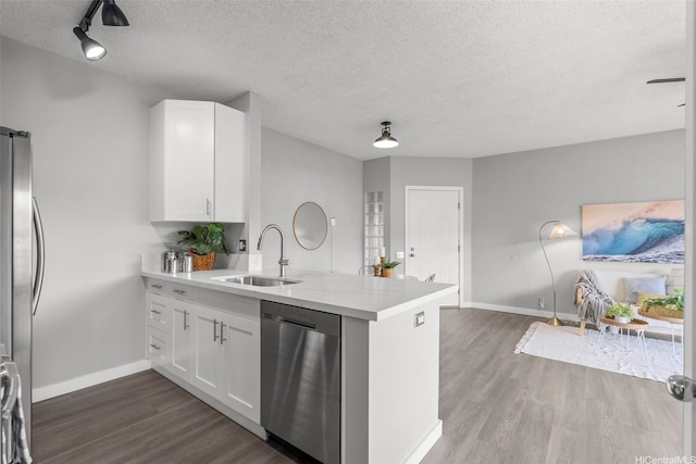 91-293 Hanapouli Cir Unit 3I, Ewa Beach, HI 96706 - kitchen featuring appliances with stainless steel finishes, a peninsula, a textured ceiling, dark wood-type flooring, and light countertops