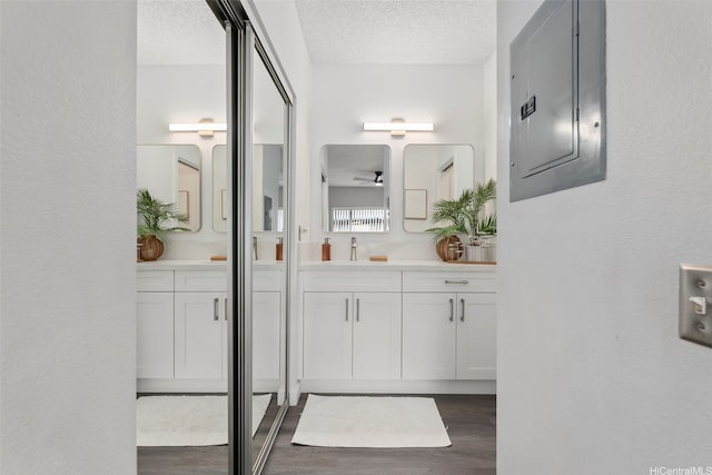 91-293 Hanapouli Cir Unit 3I, Ewa Beach, HI 96706 - bathroom featuring electric panel, wood finished floors, vanity, and a textured ceiling