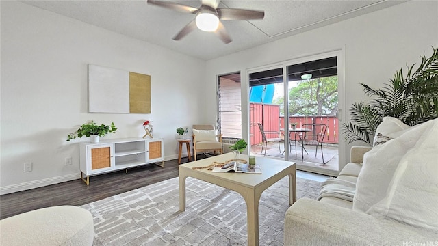 living area with baseboards, a ceiling fan, and wood finished floors