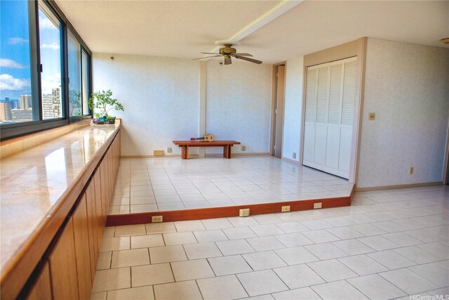 empty room featuring light tile patterned floors and ceiling fan