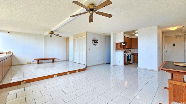 unfurnished living room featuring a ceiling fan and a textured ceiling