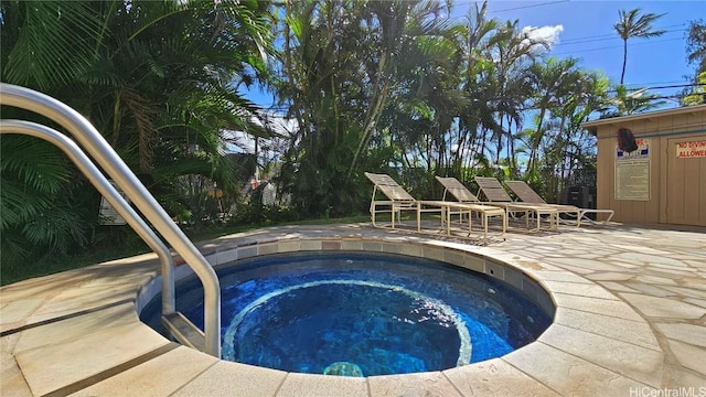 view of swimming pool featuring a hot tub and a patio area