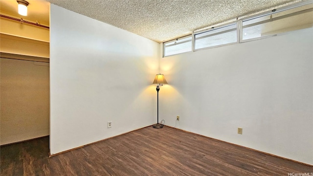 unfurnished room featuring a textured ceiling and wood finished floors