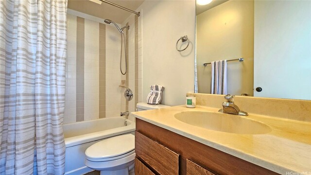 bathroom featuring vanity, shower / bath combo with shower curtain, and toilet