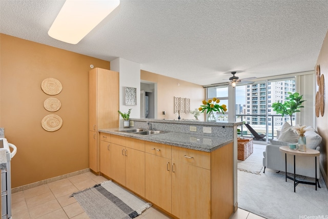 1315 Kalakaua Ave Unit 1903, Honolulu, HI 96826 - kitchen featuring a peninsula, a sink, a textured ceiling, light brown cabinetry, and ceiling fan