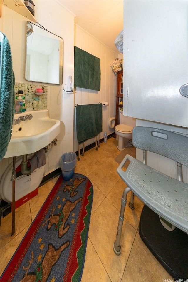 half bathroom with tile patterned floors, decorative backsplash, and toilet