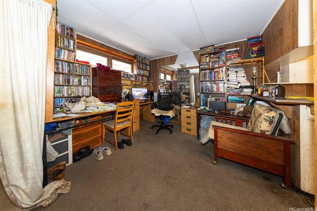 carpeted home office featuring wood walls
