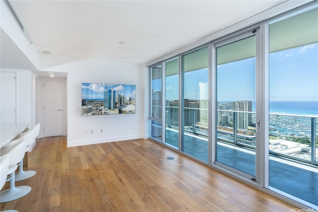 629 Keeaumoku St Unit 3801, Honolulu, HI 96814 - spare room with wood finished floors, a wall of windows, baseboards, and a water view