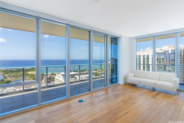 629 Keeaumoku St Unit 3801, Honolulu, HI 96814 - unfurnished living room featuring a wall of windows, healthy amount of natural light, a water view, and wood finished floors