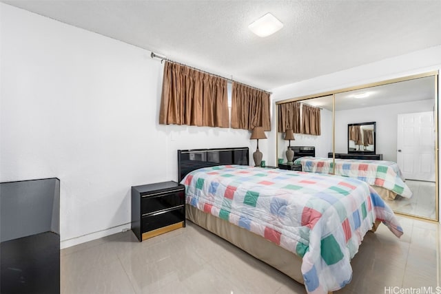 2421 Ala Wai Blvd Unit Ph1, Honolulu, HI 96815 - bedroom featuring light tile patterned floors, a closet, baseboards, and a textured ceiling