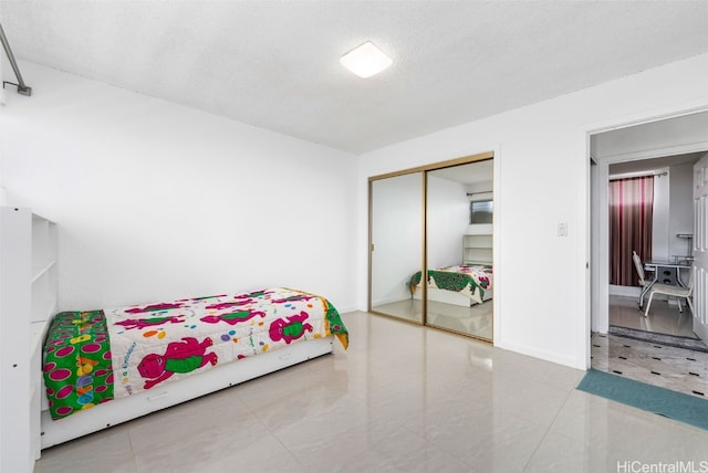 2421 Ala Wai Blvd Unit Ph1, Honolulu, HI 96815 - tiled bedroom with a closet, baseboards, and a textured ceiling