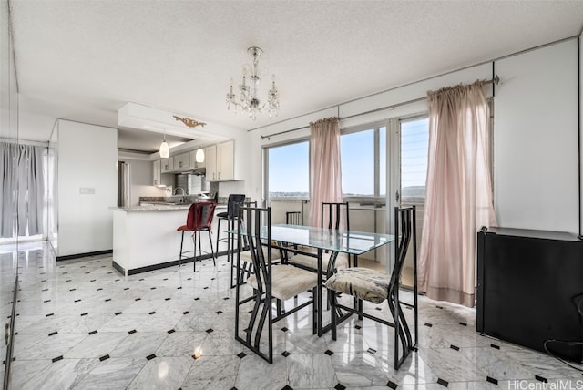 2421 Ala Wai Blvd Unit Ph1, Honolulu, HI 96815 - dining space featuring a notable chandelier, a textured ceiling, and baseboards