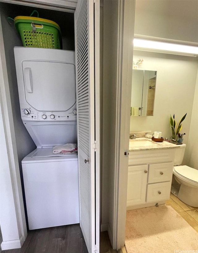 6770 Hawaii Kai Dr Unit 409, Honolulu, HI 96825 - laundry room with stacked washing machine and dryer and wood finished floors