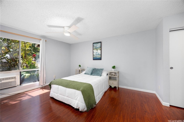 bedroom featuring a textured ceiling, wood finished floors, baseboards, ceiling fan, and cooling unit