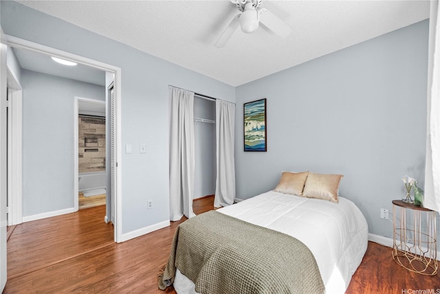 bedroom with a closet, wood finished floors, baseboards, and ceiling fan