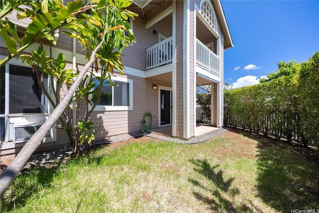 back of house featuring a balcony, a yard, and a patio
