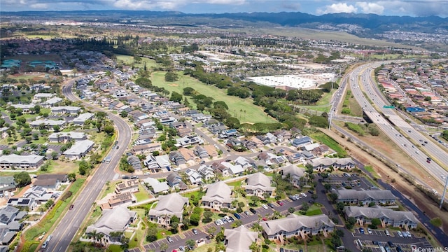 aerial view of property's location with a mountainous background, a highway, and nearby suburban area