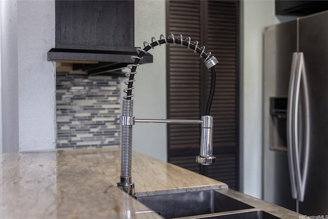 kitchen featuring stainless steel fridge and stone countertops