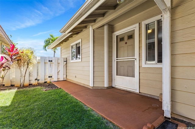 property entrance featuring a yard and fence