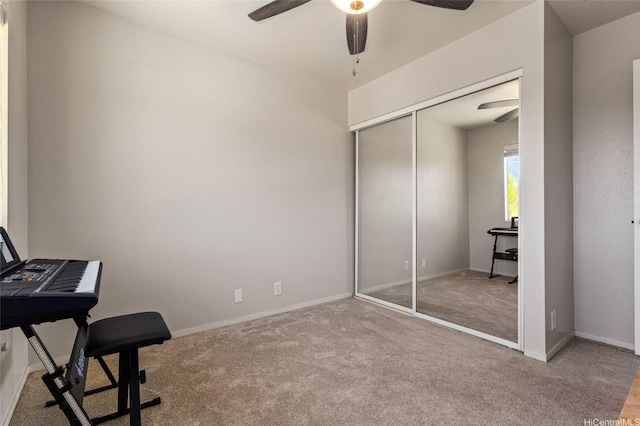 interior space featuring carpet floors, a ceiling fan, and baseboards