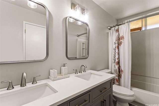bathroom featuring a sink, shower / bathtub combination with curtain, toilet, and double vanity