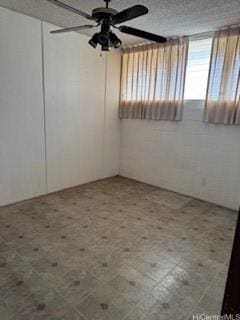 spare room with a textured ceiling and a ceiling fan