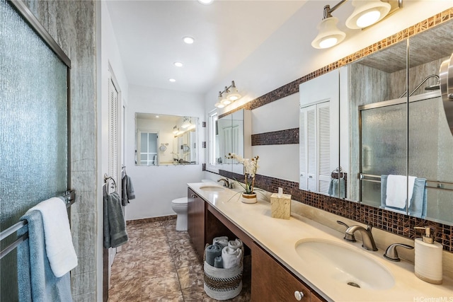 215 Koko Isle Cir Unit 5502, Honolulu, HI 96825 - bathroom featuring a closet, double vanity, toilet, baseboards, and backsplash